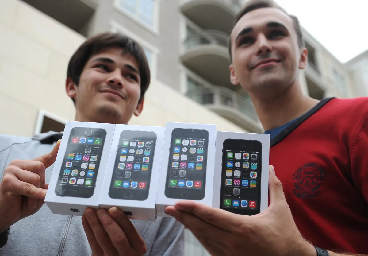 Two men display their four new iPhone 5Ss outside the Apple Store at a shopping complex in Glendale, Calif., Sept. 20. (ROBYN BECK/AFP/Getty Images)