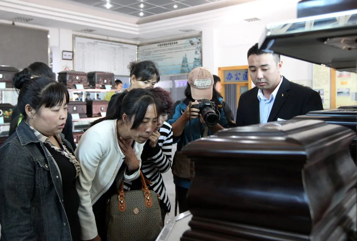Zhang Jing (2nd L) chooses a box to hold the ashes of her husband Xia Junfeng, a 36-year-old street vendor, at Dongling Funeral Home on Sept. 26, 2013 in Shenyang, China. Xia Junfeng was executed for killing two urban management officers in 2009, with the result widely seen as an example of unequal justice. (ChinaFotoPress/Getty Images)