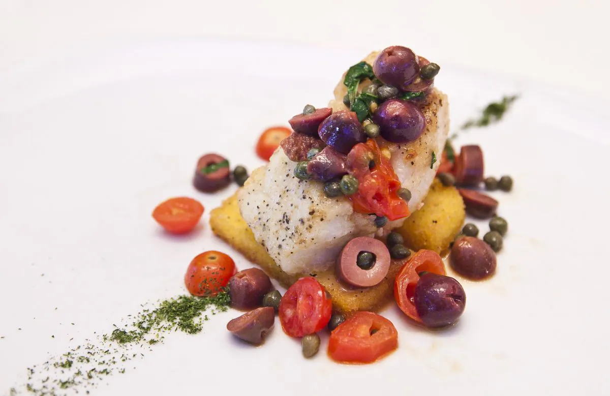 Baccala’ alla Livornese con Polenta ($22.95), cod fillet with black olives, capers, and tomatoes. (Samira Bouaou/Epoch Times)