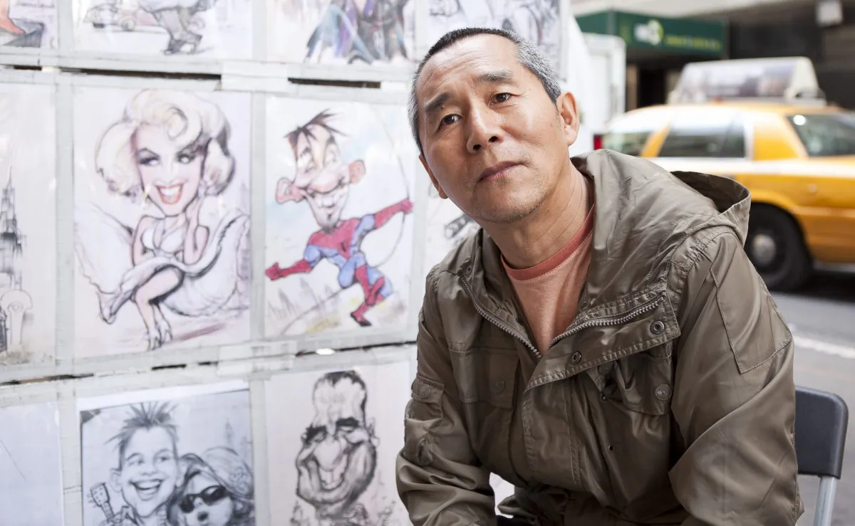 Wang Lu Ri, a Buddhist artist who gave up an 8-year graduate degree to suffer and draw caricatures in Times Square, Sept. 5. (Samira Bouaou/Epoch Times)