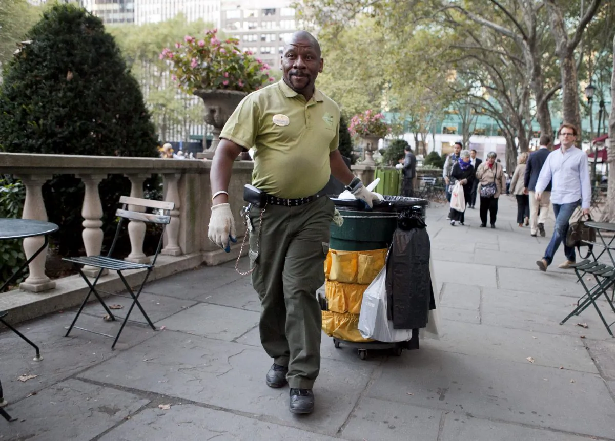 A sanitation worker empties trash bins in Bryant Park, New York City, Sept. 17, 2013. (Samira Bouaou/Epoch Times)
