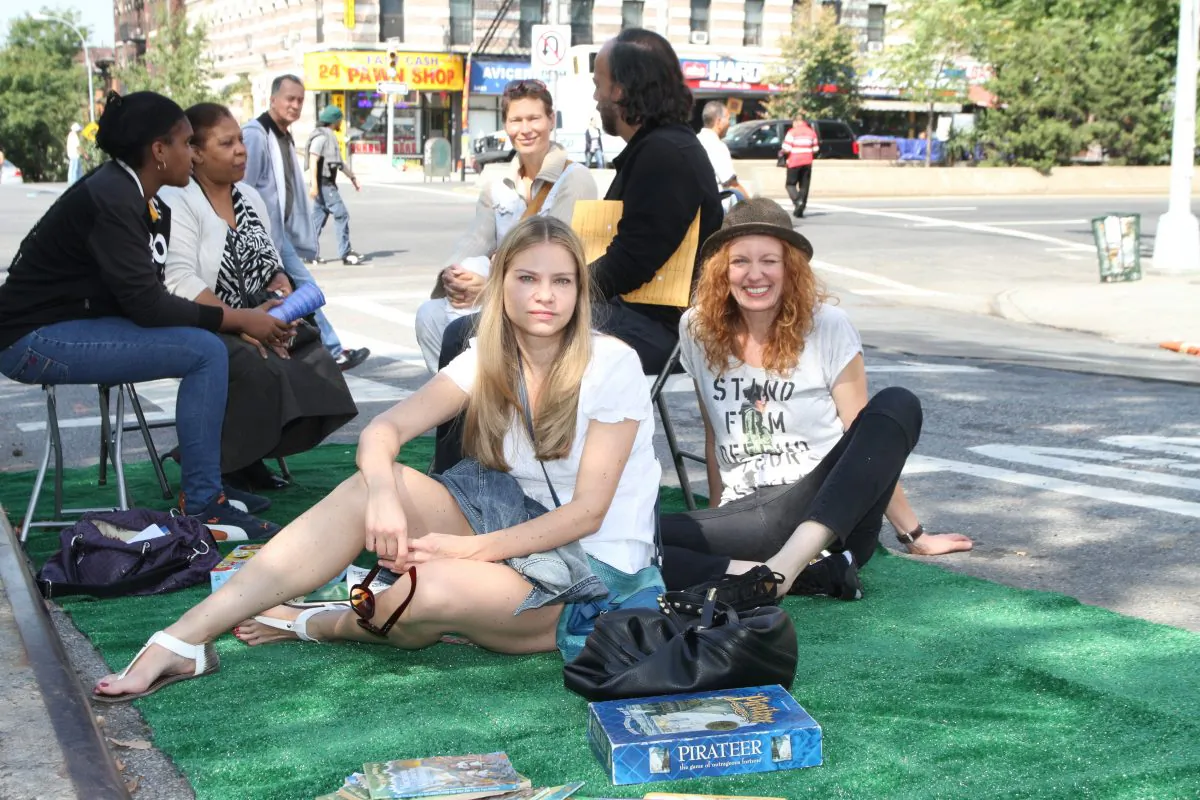 Aleksandra Bielska (L), and her friend Beata Frankowicz(R), who are visiting New York from Poland, are camping out on the tuft set up by the Montefiori Park Neighborhood Association on 138th Street and Broadway, Sept. 20, 2013. This day marks the international Park(ing) Day initiative, celebrated in 162 cities around the world. (Kristina Skorbach/Epoch Times)