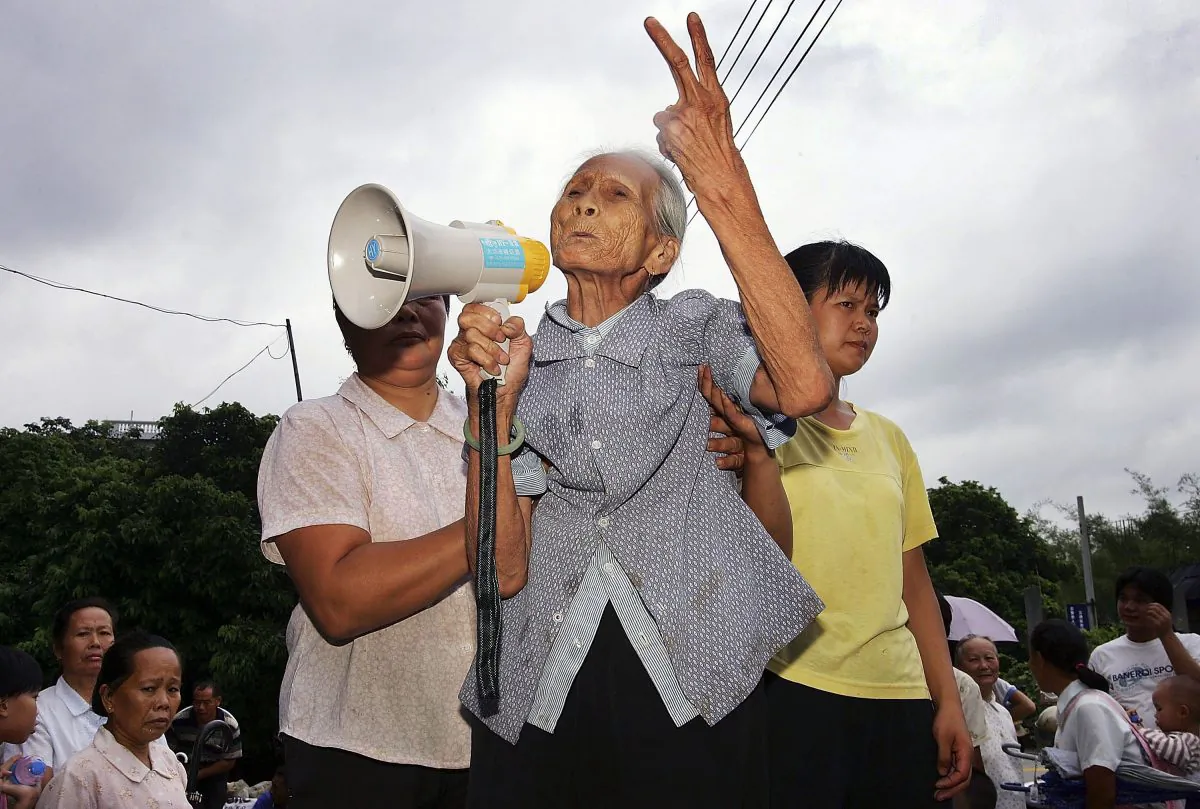An octogenarian grandmother gets up on a pile of rocks in her bare feet to give a speech against the corruption of the village secretary, at a villagers' meeting of Taishi Village on July 31, 2005 in Guangzhou of Guangdong Province. Ma Qiang argues that such abuses of power are common. (China Photos/Getty Images)