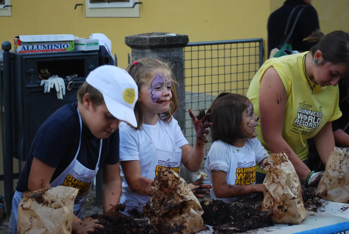 Children work on the Guinness World Record attempt at the longest chocolate sausage in the Italian town of Cavalese, Sept. 13, 2013. (Vincenzo Cassano/Epoch Times)