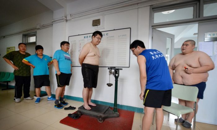 Overweight people checking their weights after their acupuncture and exercise treatment at the Aimin (Love the People) Fat Reduction Hospital in the northern port city of Tianjin, China, June 14, 2012. (Mark Ralston/AFP/Getty Images)