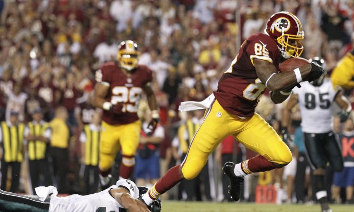 Washington Redskins wide receiver Leonard Hankerson, right, breaks a tackle by Philadelphia Eagles cornerback Jordan Poyer as he heads toward the end zone for a touchdown during the second half of an NFL football game in Landover, Md., Monday, Sept. 9, 2013. (AP Photo/Alex Brandon)