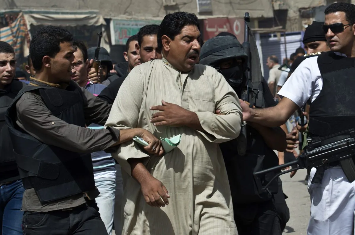 Egyptian policemen arrest a man during a raid in the village of Kerdassah on the outskirts of Cairo, Sept. 19, 2013. (Khaled Desouki/AFP/Getty Images) 