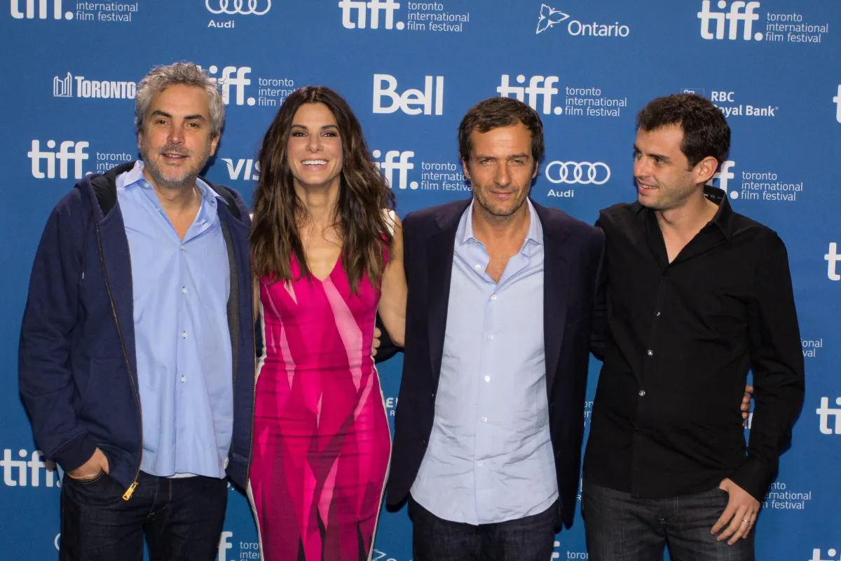 Director Alfonso Cuarón and actress Sandra Bullock, producer David Heyman and writer Jonas Cuarón pose for photos before a press conference Monday about their acclaimed movie Gravity which made its world premier at the Toronto International Film Festival. (Dali Sun/Epoch Times)