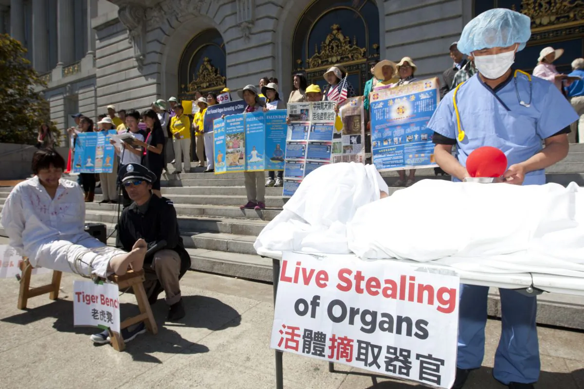 Actors re-enact organ harvesting and torture being done on Falun Gong practitioners, while demonstrators hold signs at a press conference to support House Resolution 281 against organ harvesting in China, at San Francisco City Hall, Sept. 5, 2013. (Epoch Times)
