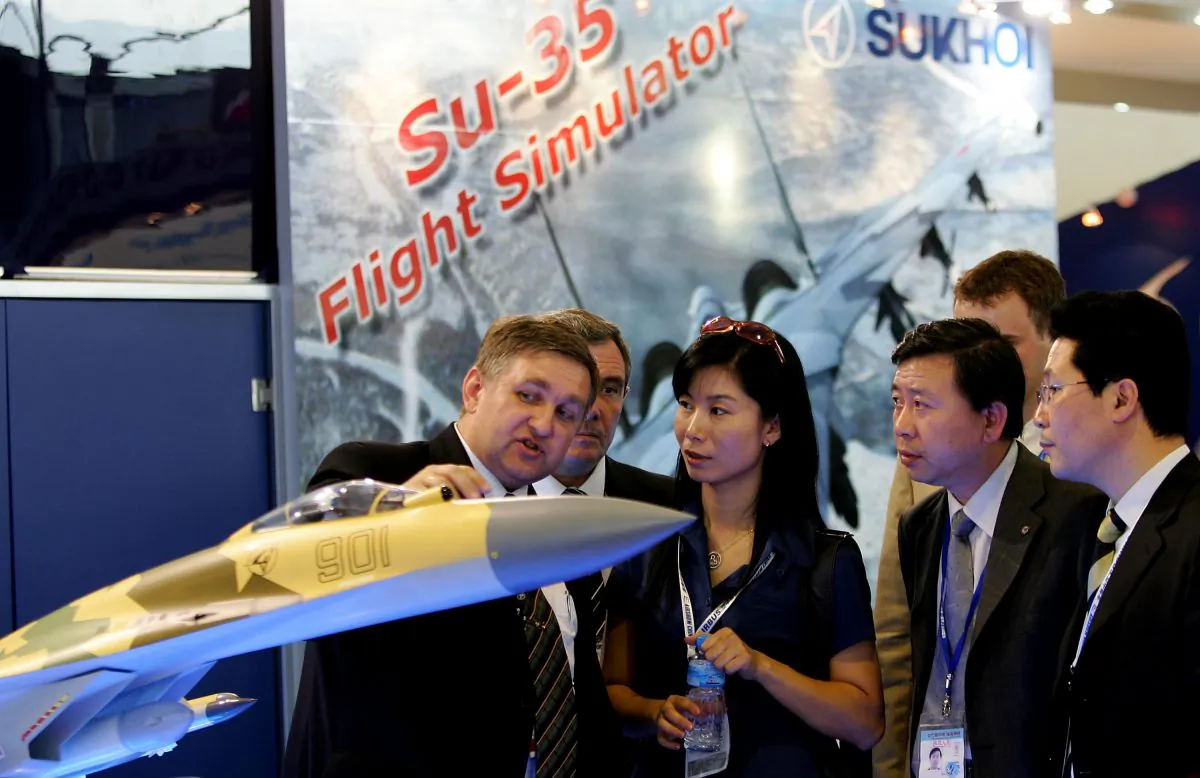A man describes the Russian Su-35 fighter jet to Chinese visitors at Airshow China 2006 on Nov. 1, 2006 in Zhuhai, China. The Chinese regime is expected to sign a deal with the Russians to obtain the Su-35 next year. (Guang Niu/Getty Images)