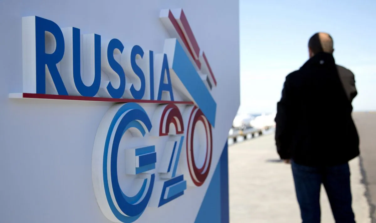 A journalist speaks on a cellphone next to a sign for the G20 summit in St. Petersburg. As world leaders began arriving for the summit on Wednesday, Canada was holding out little hope of reaching a compromise with Russia on the continuing violence and alleged use of chemical weapons in Syria. (AP Photo/Virginia Mayo) 