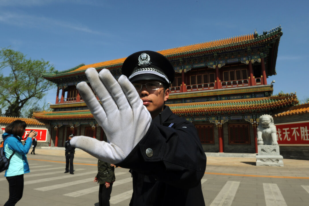 A policeman blocks photos from being taken outside Zhongnanhai, the central headquarters for the Chinese Communist Party, in Beijing, on April 11, 2012. (Mark Ralston/AFP/Getty Images)