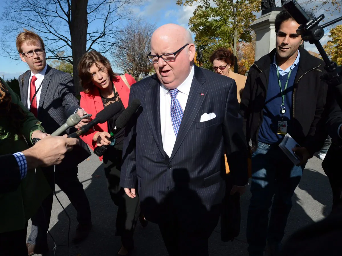 Sen. Mike Duffy is questioned by media as he arrives at the Senate on Parliament Hill in Ottawa on Tuesday, Oct. 22, 2013. In the House of Commons on Oct 23, Prime Minister Stephen Harper accused Duffy of playing the victim card because he was ordered to repay inappropriate expenses. (The Canadian Press/Sean Kilpatrick)