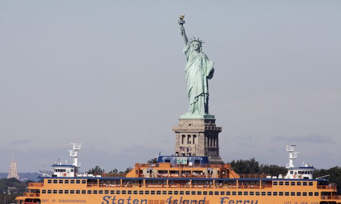 In this Oct. 1, 2012 file photo, the Staten Island Ferry passes the Statue of Liberty as it crosses New York Harbor. (Mark Lennihan/AP Photo)