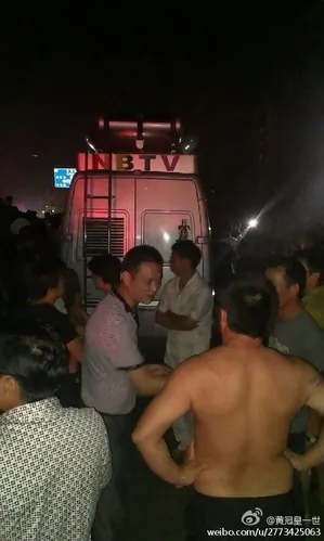 The NBTV van is stopped by crowds angry at a reporter's false report about the flooding in Zhejiang Province, on Oct. 11, 2013. (Weibo.com)