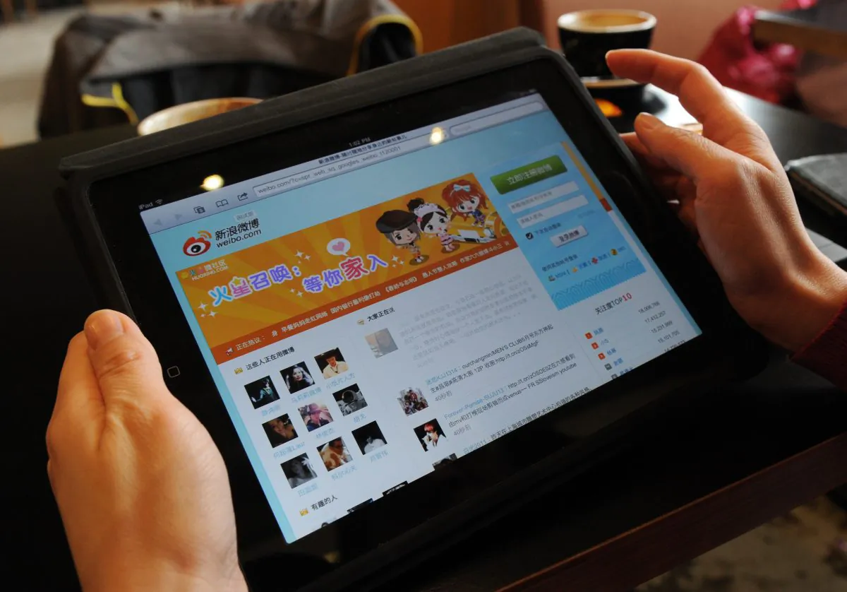 A woman views the Chinese social media website Weibo at a cafe in Beijing on April 2, 2012. The Chinese regime’s latest gambit for controlling an unruly Internet has been to arrest “troublemakers” who post information about corruption to a tip-off website. (Mark Ralston/AFP/Getty Images)