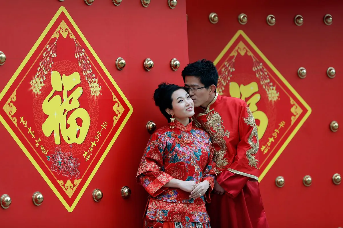 A couple in traditional Chinese clothing pose for wedding portraits in Beijing on Valentine’s Day on Feb. 14, 2013. (Lintao Zhang/Getty Images)