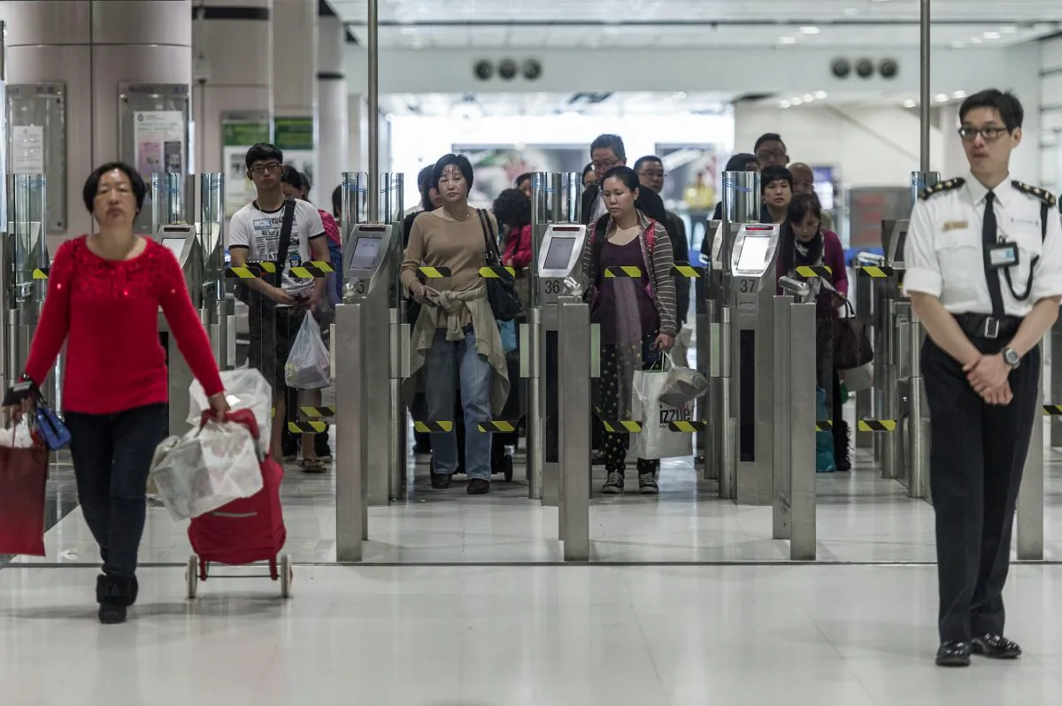 People proceed to an immigration checkpoint at a border crossing point of mainland China with Hong Kong on March 1, 2013. Hong Kong has no control over who immigrates to it from China. (Philippe Lopez/AFP/Getty Images)