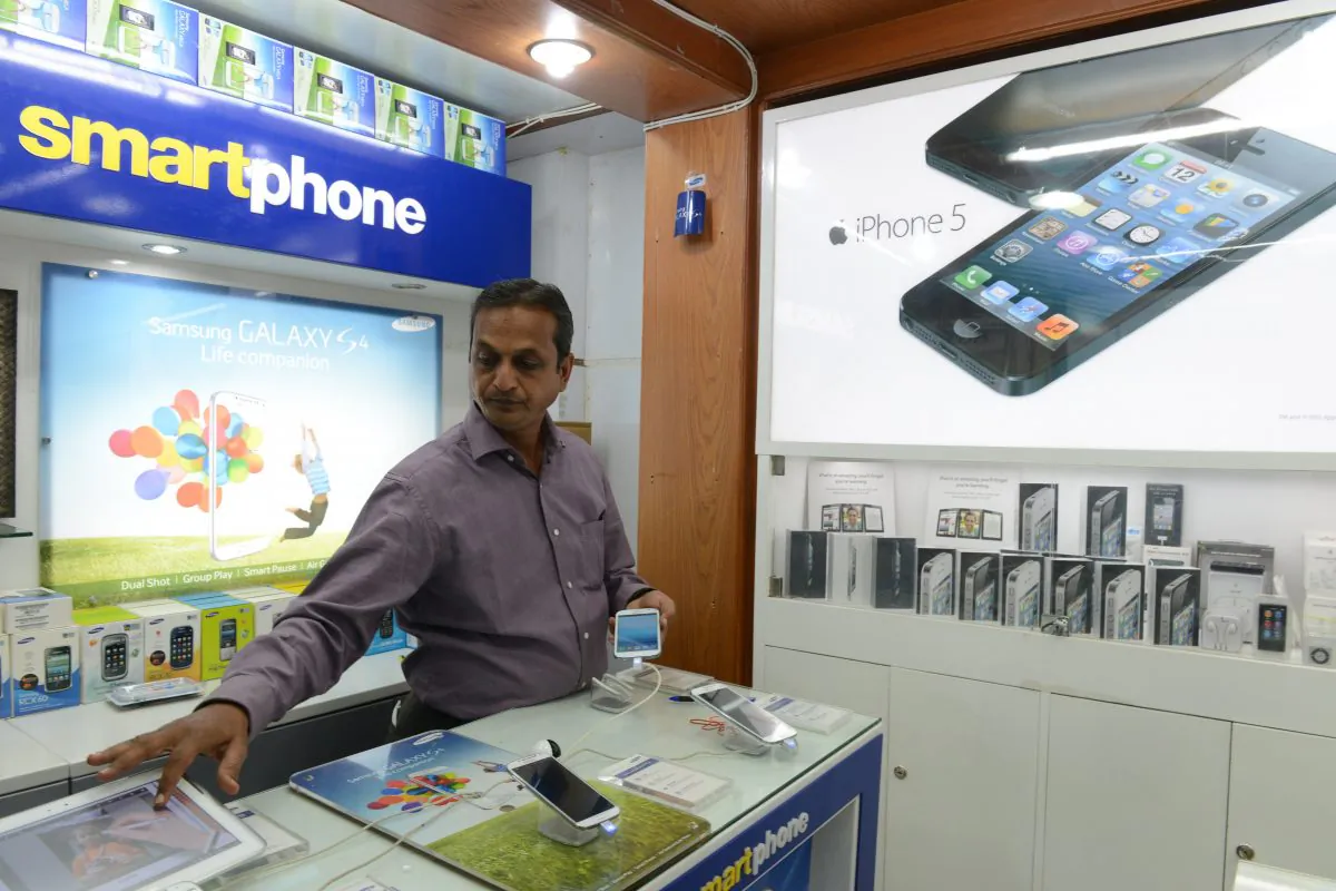 A vendor looks at a display of smart phones at his mobile store in Secunderabad, the twin city of Hyderabad, Indian, on Aug. 28, 2024. (Noah Seelam/AFP/Getty Images)