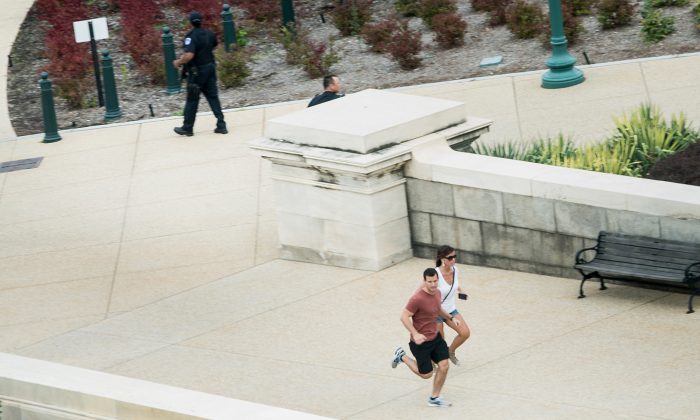 People run for cover as police converge to the site of a shooting October 3, 2013 on Capitol Hill in Washington, DC. (Brendan Smialowski/AFP/Getty Images)