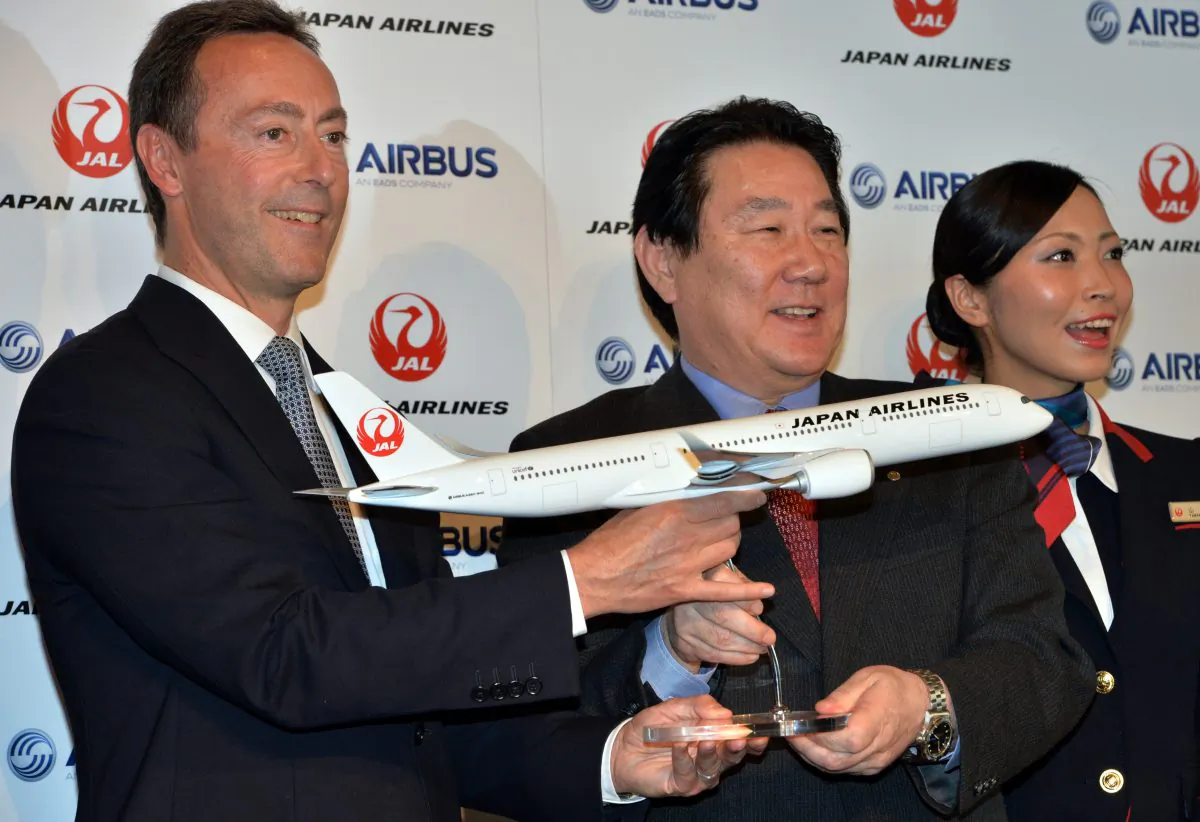 (L-R) Airbus president Fabrice Bregier, Japan Airlines president Yoshiharu Ueki, and a JAL cabin attendant display a scale model of Airbus A350 in Tokyo, Japan, Oct. 7. (YOSHIKAZU TSUNO/AFP/Getty Images)