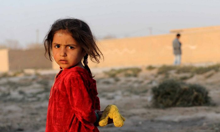 An Afghan girl looks on as she holds her doll on the outskirts of Mazar-i-Sharif on October 13, 2013. Some nine million Afghans or 36 percent of the population are living in 'absolute poverty' while another 37 percent live barely above the poverty line, according to a UN report (Farshad Usyan/AFP/Getty Images)