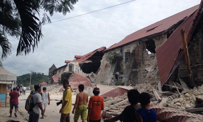 People walk past the damaged Church of San Pedro in the town Loboc, Bohol after a major 7.2 magnitude earthquake struck the region on October 15, 2013. (Robert Michael Poole/AFP/Getty Images)