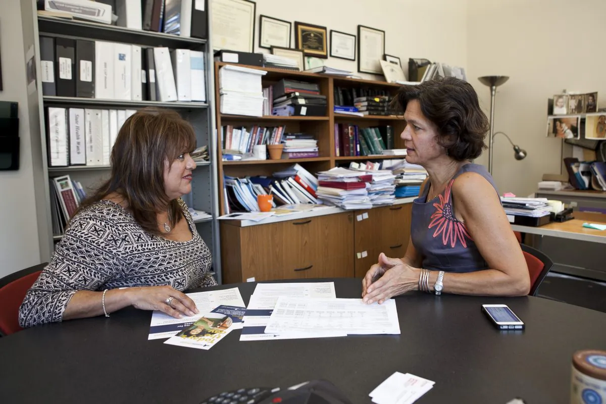 Bronx resident Madeline Aviles (L) talks to Elisabeth Benjamin, vice president of health initiatives at the Community Service Society of New York, about enrolling in a health plan, New York City, Oct. 1, 2013. Benjamin is one of five in-person enrollment assistants, or navigators, at the society’s offices in Midtown Manhattan. (Samira Baoaou/Epoch Times)