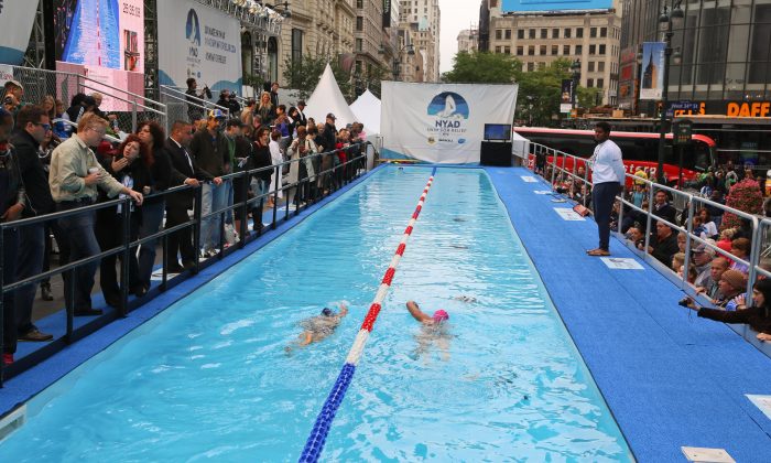 Diana Nyad (R) and a supporter swim in a custom-made pool set up in Herald Square in New York City on Oct. 9, 2013. (Christian Watjen/Epoch Times)