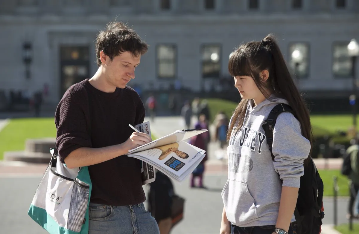 Stephen Petro signs the petition in support of H.Res. 281 to stop forced organ harvesting of Falun Gong practitioners in China, set up by the Falun Dafa Club, on the stairs of Low Memorial Library at Columbia University, New York, Oct. 15, 2013. (Samira Bouaou/Epoch Times)
