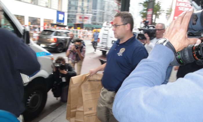 Police officers carry two biological evidence bags out of a Victoria's Secret store near Herald Square in New York City on Oct. 17, 2013. (Sarah Matheson/Epoch Times)