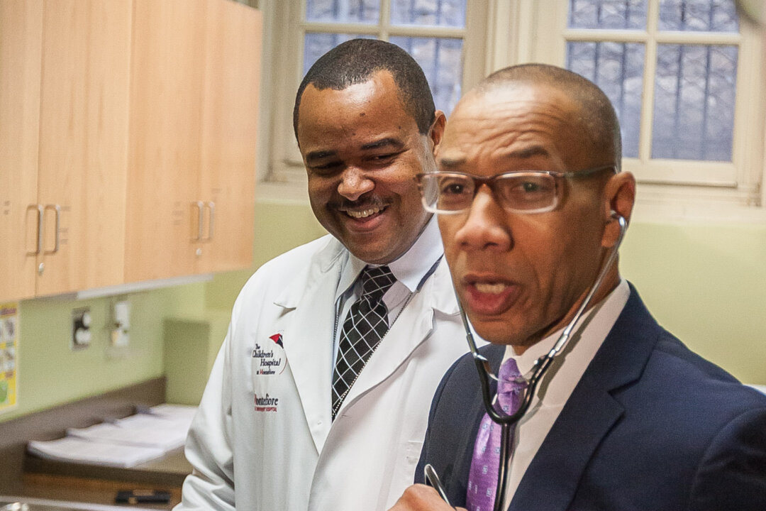 New York City Department of Education Chancellor Denis Walcott (R) tours the facilities of the new school health center with Shawn Bowen, the center's pediatrician, in Morris Educational Campus in the South Bronx, New York, Oct. 21, 2013. (Petr Svab/Epoch Times)