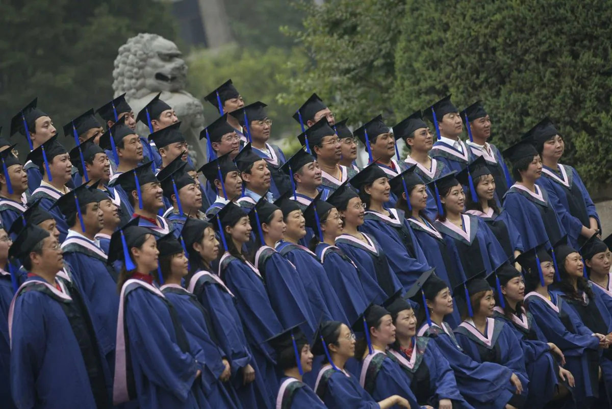 In this file photo, graduates with a master’s degree pose for pictures during a graduation ceremony at Peking University on June 24, 2006, in Beijing, China. (China Photos/Getty Images)