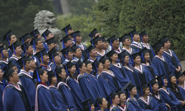 In this file photo, graduates with a master’s degree pose for pictures during a graduation ceremony at Peking University on June 24, 2006, in Beijing, China. (China Photos/Getty Images) 