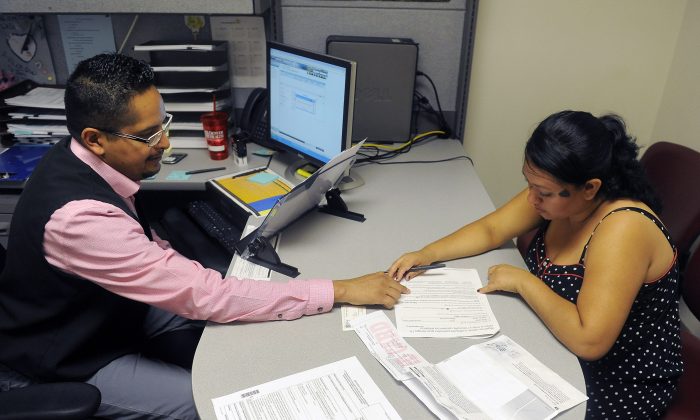 Enrollment Specialist Horacio Castaneda (L) helps Rosa Ayala Cruz apply for health benefits at the Denver Health Westside Family Health Center on Oct. 01, 2013 in Denver. (Chris Schneider/Getty Images)