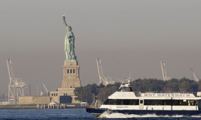 A commuter ferry passes the Statue of Liberty in New York City, Oct. 1, 2013. Statue of Liberty, like other national monuments, is closed due to the government shutdown. (Mark Lennihan/AP Photo)