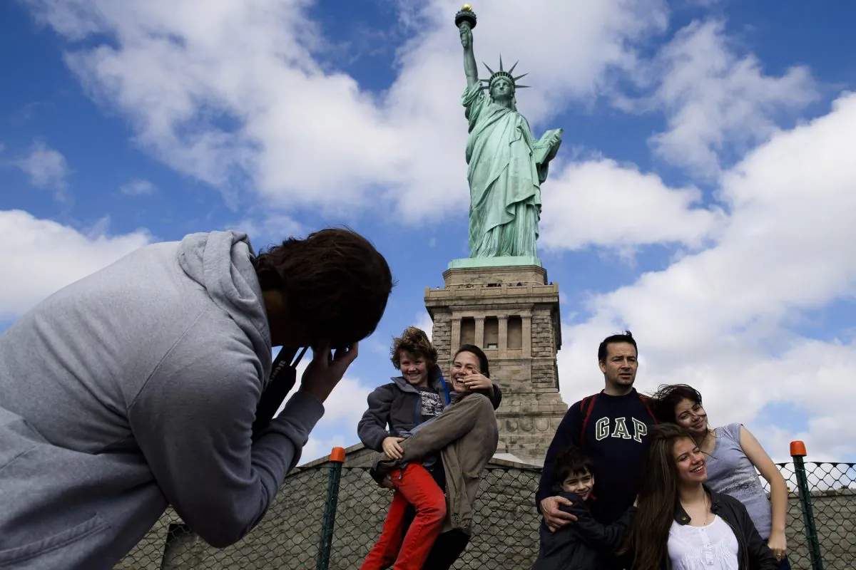 Tourists pose for photographs in front of the Statue of Liberty in New York Harbor, Oct. 13. 2013. (John Minchillo/AP)
