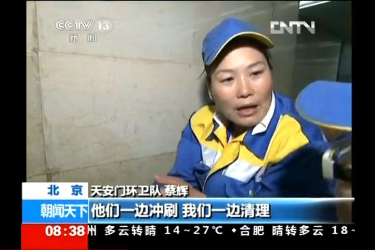A cleaner is interviewed by China Central Television, about an article featuring trash strewn on the ground on Tiananmen Square, a phenomenon taken as an indication of the popularity of the event by Chinese state media. (Screenshot/CCTV/Epoch Times)