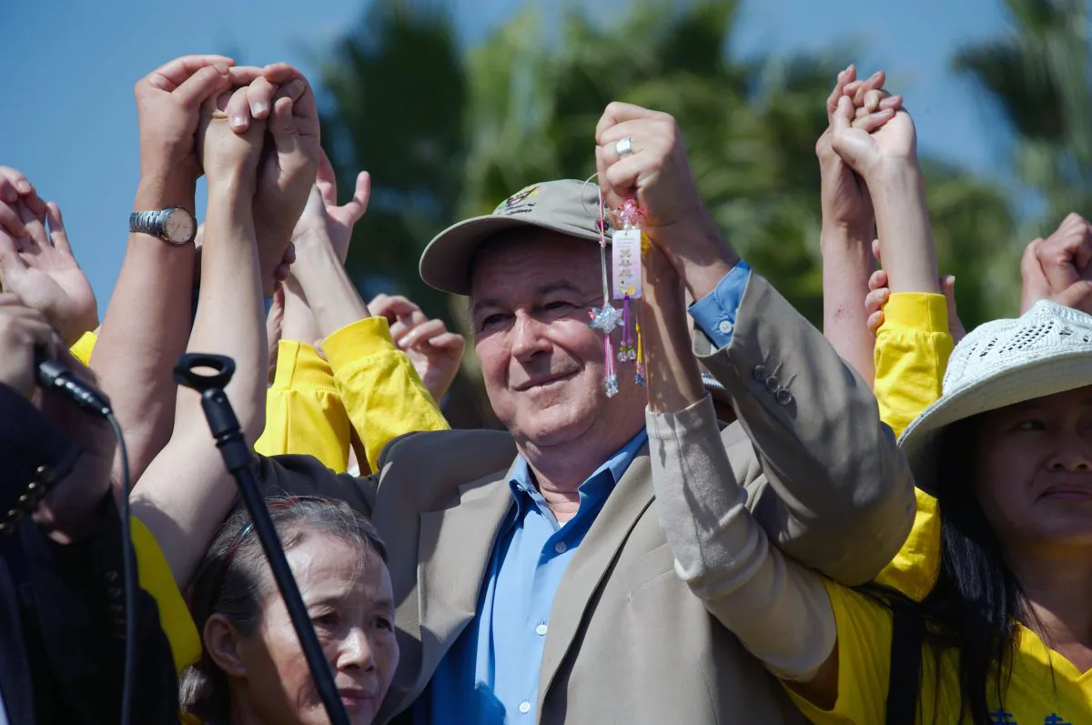 Rep. Rohrabacher holds hands as a symbol of unity with over 100 Falun Gong torture survivors at a rally in Long Beach, Oct. 20. (Robin Kemker/The Epoch Times)