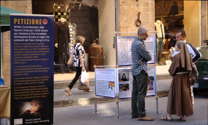 A volunteer with Doctors Against Forced Organ Harvesting introduces a petition calling on China to cease harvesting organs from prisoners of conscience to passersby in Calimala Street in Florence, Italy, on Sept. 22, 2013. (Courtesy of Doctors Against Forced Organ Harvesting)