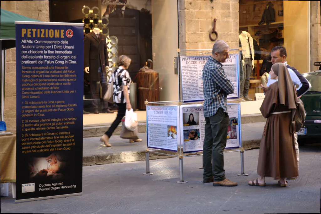 A volunteer with Doctors Against Forced Organ Harvesting introduces a petition calling on China to cease harvesting organs from prisoners of conscience to passersby in Calimala Street in Florence, Italy, on Sept. 22, 2013. (Courtesy of Doctors Against Forced Organ Harvesting)