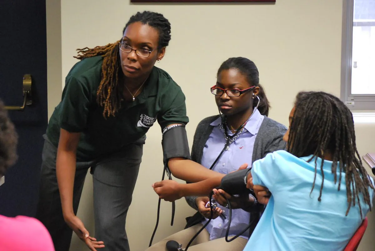 Renée Volny, OB/GYN, shows students how to read a blood pressure meter at the Tour for Diversity in Medicine at the Georgetown University School of Medicine, Sept. 28. (Ron Dory/Epoch Times)