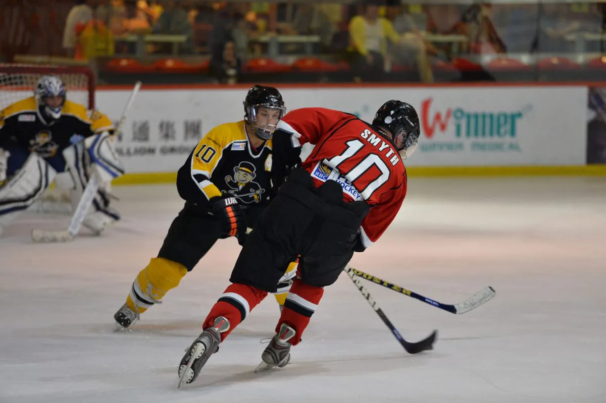 Kowloon Warriors number 10, Gregory Smyth is held up on his way to the Hong Kong Tycoons goal by his opposite number, Jacob Trost during the week-2 match Saturday Oct 12. (Bill Cox/Epoch Times)
