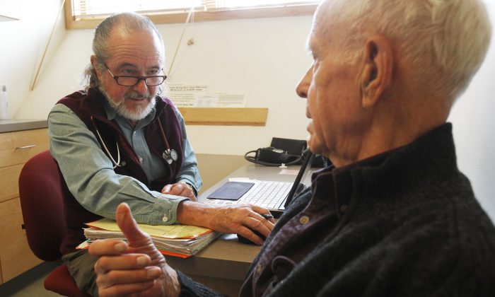 Ronald Pitkin (R) talks with Dr. John Matthew during an office visit in Plainfield, Vt. on June 6, 2013. (Toby Talbot/AP)