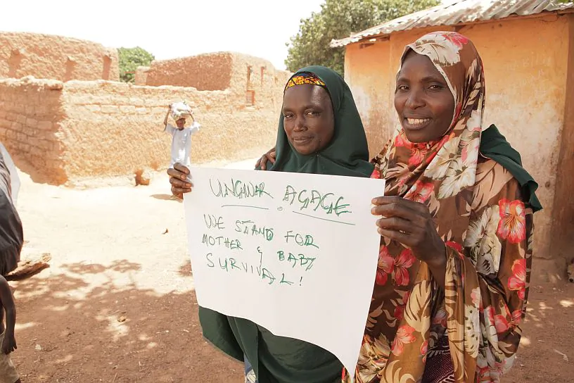 Women holding a sign saying "We stand for mother & baby survival!" in Katsina, northern Nigeria. (Courtesy of Okikiola Akinkugbe)