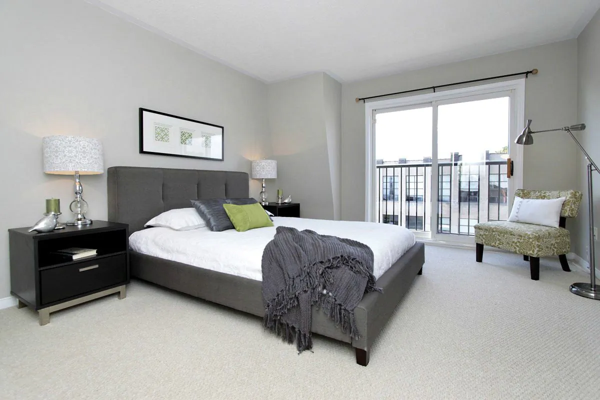 In this bedroom, the chair acts as an accent that ties in the neutral colours of the walls and bed frame to the bolder lime green found in the artwork, tabletop accessories, and accent pillow on the bed.(Courtesy Feels Like Home 2 Me, feelslikehome2me.com)