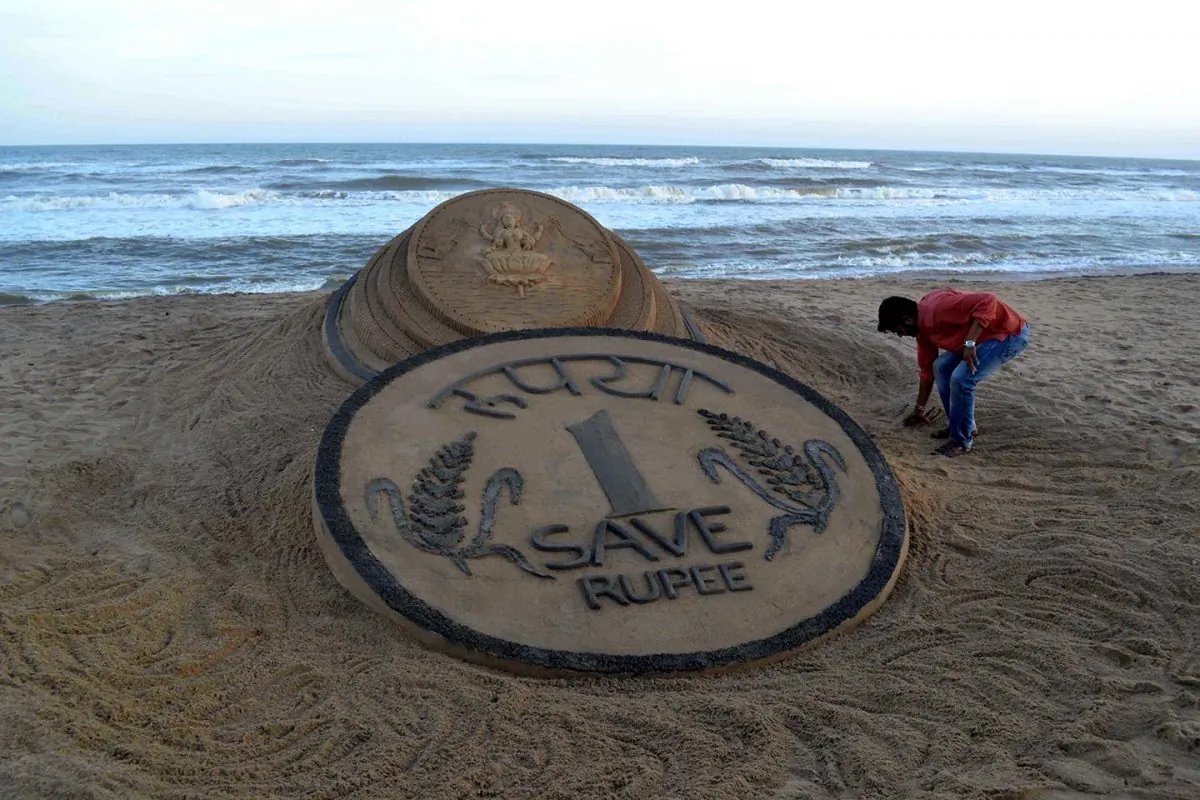 Indian sand artist Sudarsan Pattnaik puts the finishing touches to his sand sculpture of a rupee coin in front of a Hindu Goddess on the beach at Puri, some 65km from Bhubaneswar on August 22, 2013. The rupee, which has hit record low against the U.S. dollar has not deterred those with dreams to go abroad as the returns on investment have also increased manifold times. (Strdel/AFP/Getty Images)
