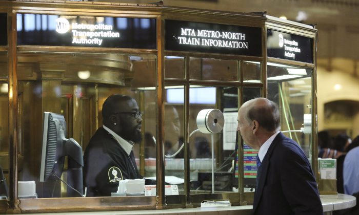 A Metro-North customer service agent helps a morning rush-hour commuter with train information at Grand Central Terminal in New York City, Sept. 26, 2013. (Mary Altaffer/AP Photo)