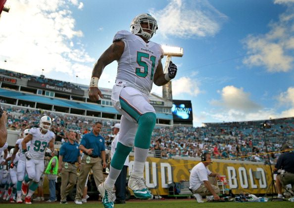  Mike Pouncey #51 of the Miami Dolphins leads the team onto the field during a preseason game against the Jacksonville Jaguars at EverBank Field on August 9, 2013 in Jacksonville, Florida. (Photo by Mike Ehrmann/Getty Images)