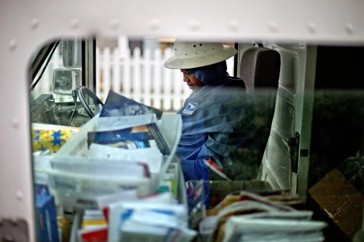 U.S. Postal Service letter carrier Jamesa Euler delivers mail, in Atlanta, Feb. 7, 2013. (AP Photo/David Goldman)